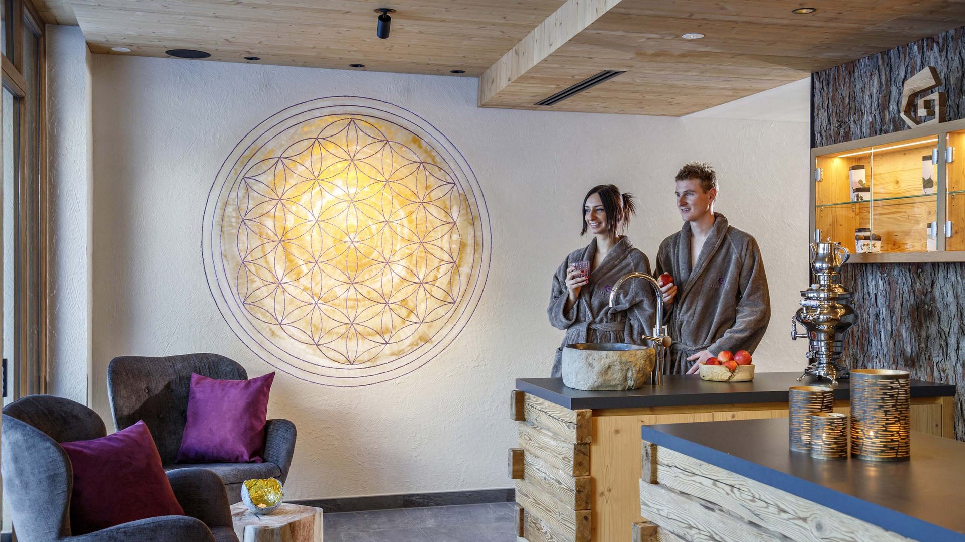 Hotel a Racines con centro benessere Coppia in accappatoi in un moderno centro benessere con legno e poltrone comode