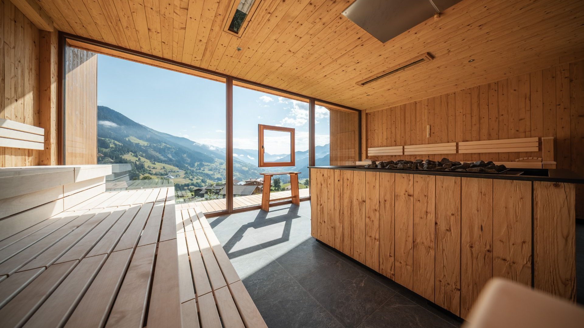 L’area wellness riservata agli adulti Sauna in legno con finestre panoramiche e vista sulle montagne alpine