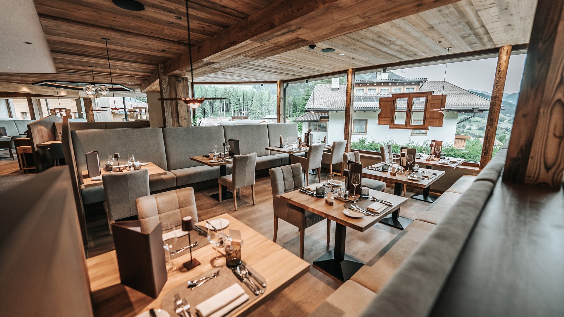 The Gassenhof gourmet cuisine Modern restaurant with wooden furniture and large windows overlooking mountains