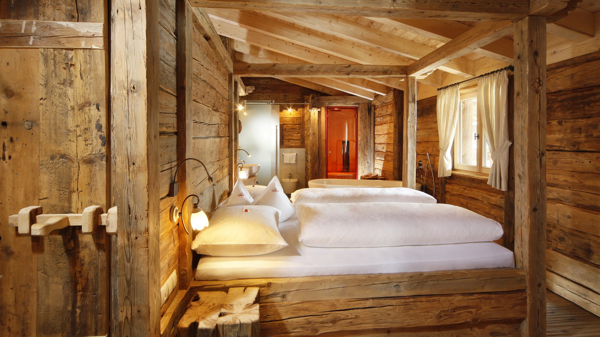 The historical Chalet Gratznhäusl Rustic bedroom with wood paneling and open bathroom in country style