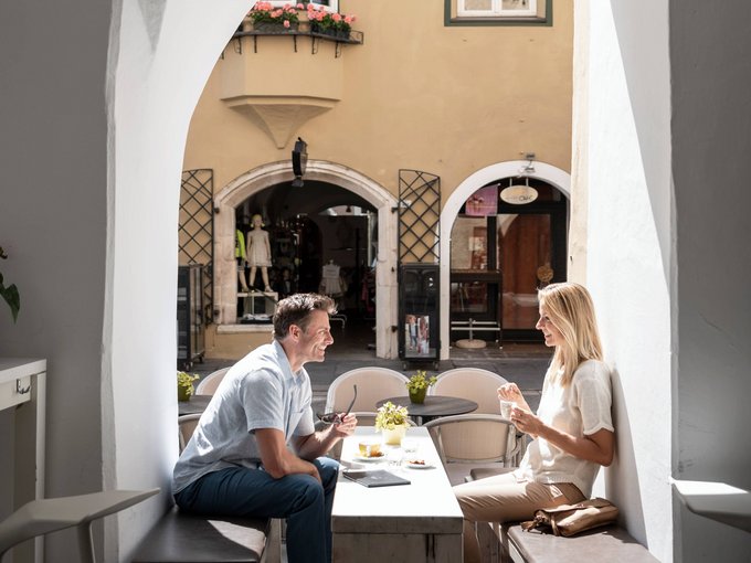 Your holiday in Vipiteno/Sterzing Couple sitting at a table under an arch in a charming café