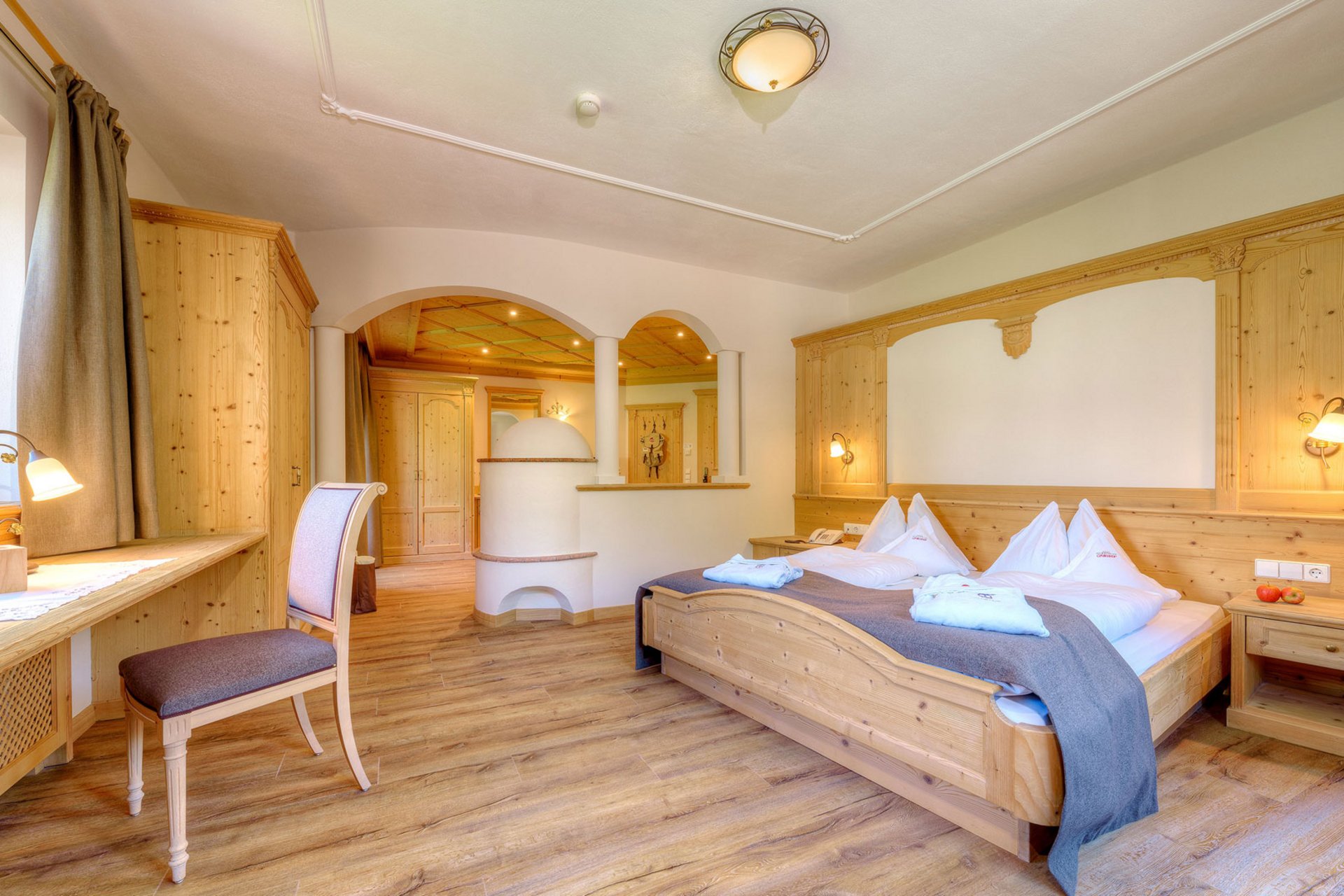 Urlaub anfragen Gemütliches Hotelzimmer mit Holzmöbeln und Doppelbett
