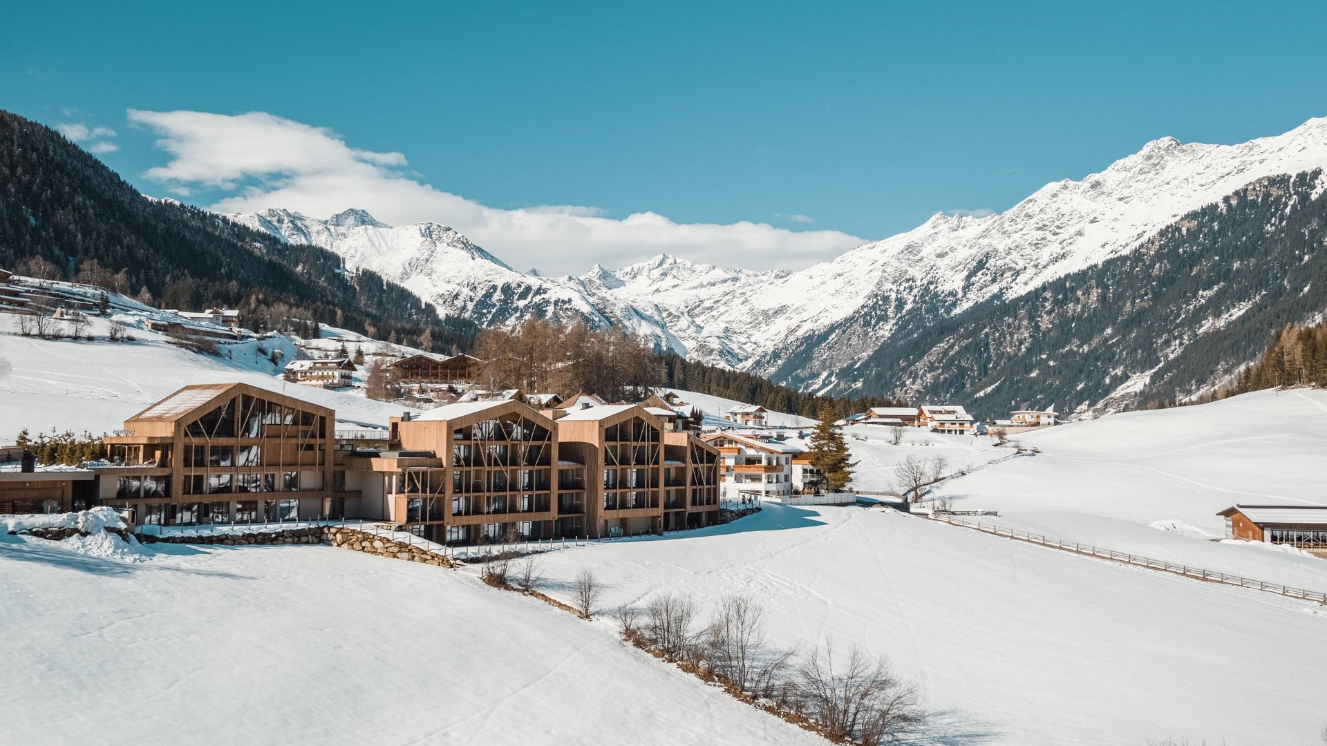 Offerte Edifici in legno in valle innevata con montagne sullo sfondo