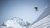 Skifahrer springt von einer schneebedeckten Klippe in den Bergen
