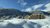 Modernes Hotel in schneebedeckter Berglandschaft unter blauem Himmel