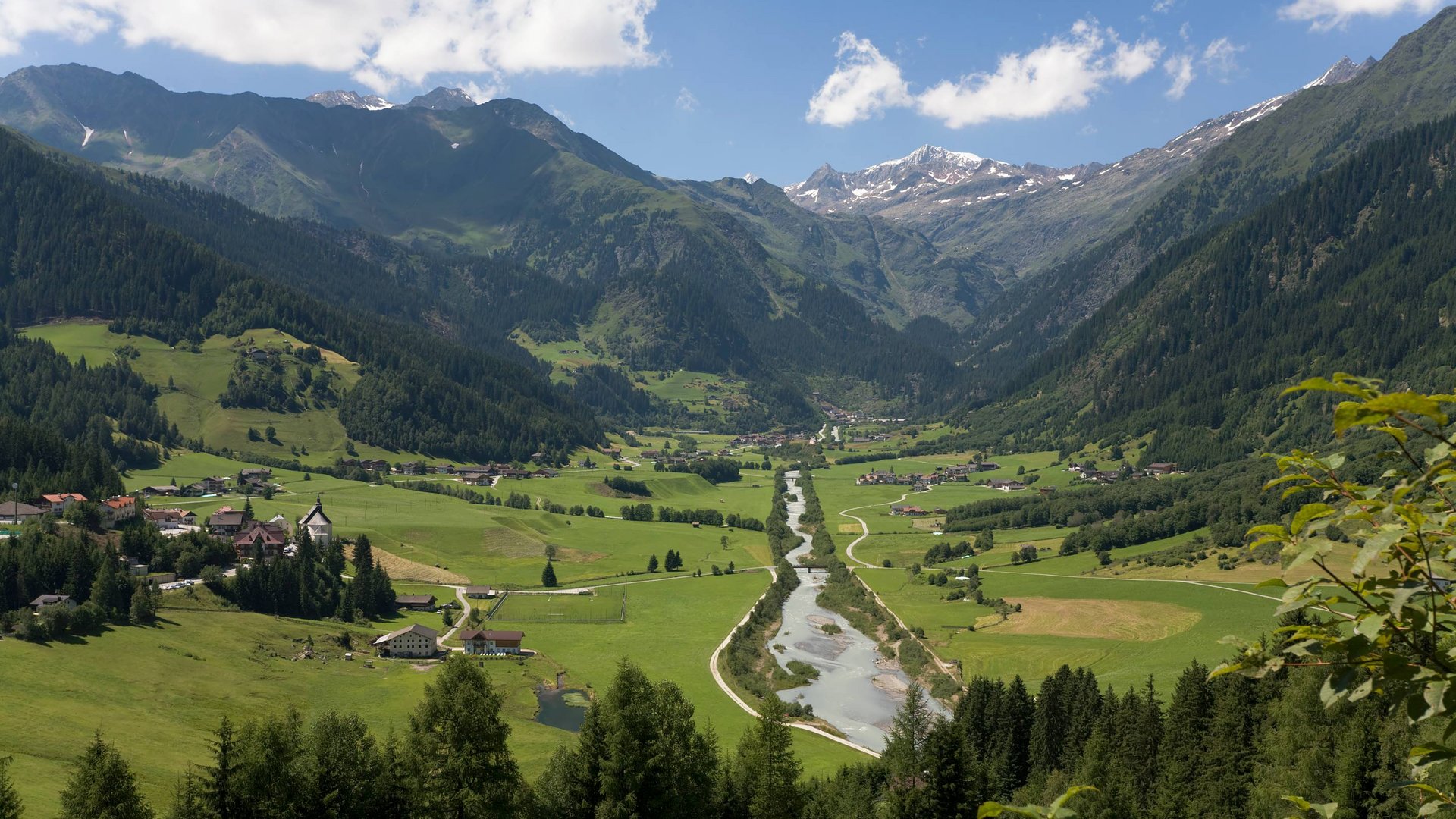 La Val Ridanna Valle con fiume, prati verdi e montagne sotto cielo azzurro