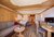 Gemütliches Hotelzimmer mit Holzmöbeln, Couch, Bett, TV und Esstisch
