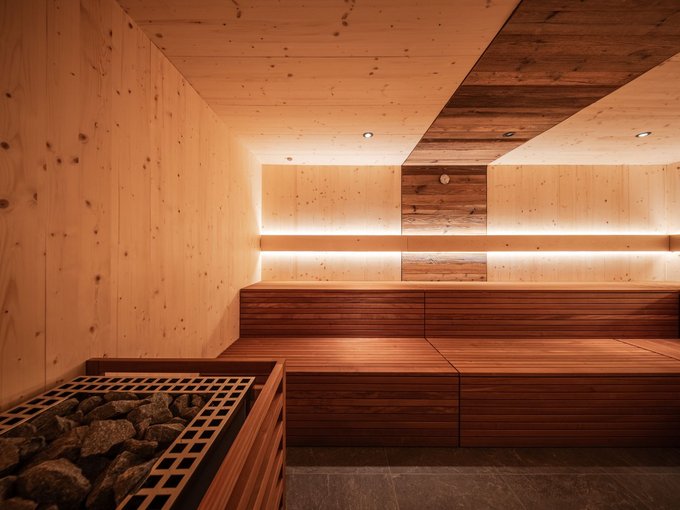 Gassenbadl: l’area wellness per famiglie Sauna in legno con panche e stufa con pietre