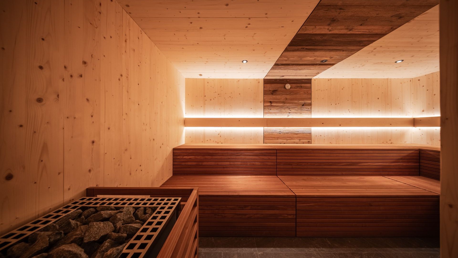 Gassenbadl: l’area wellness per famiglie Sauna in legno con panche e stufa con pietre