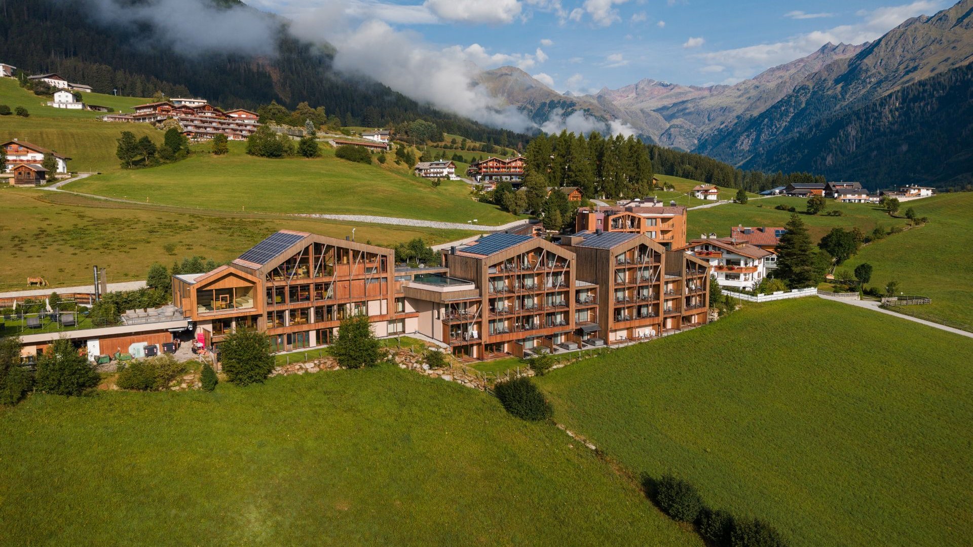 Home Erlebnisort Gassenhof Alpine hotel surrounded by green meadows, forested slopes and mountains