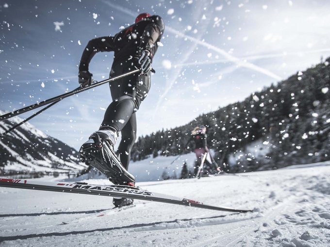 Cross-country skiing in and around Ridnaun Cross-country skier on snowy mountain trail under clear sky