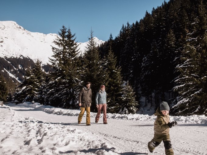 Aktivitäten mit Kindern im Ridnauntal Zwei Erwachsene und ein Kind wandern durch eine verschneite Berglandschaft