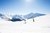 Zwei Skifahrer auf verschneiter Piste mit Bergen bei klarem Himmel