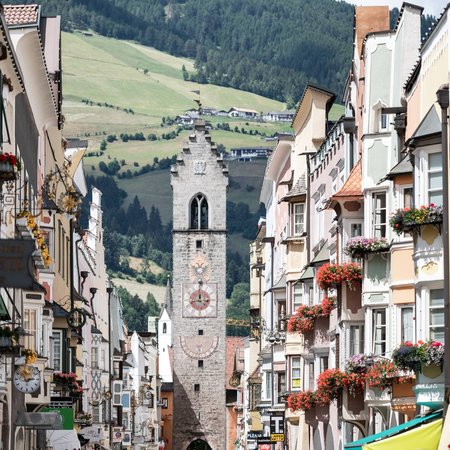 La Val Ridanna Vista di una strada del centro storico con torre dell'orologio storica e case colorate