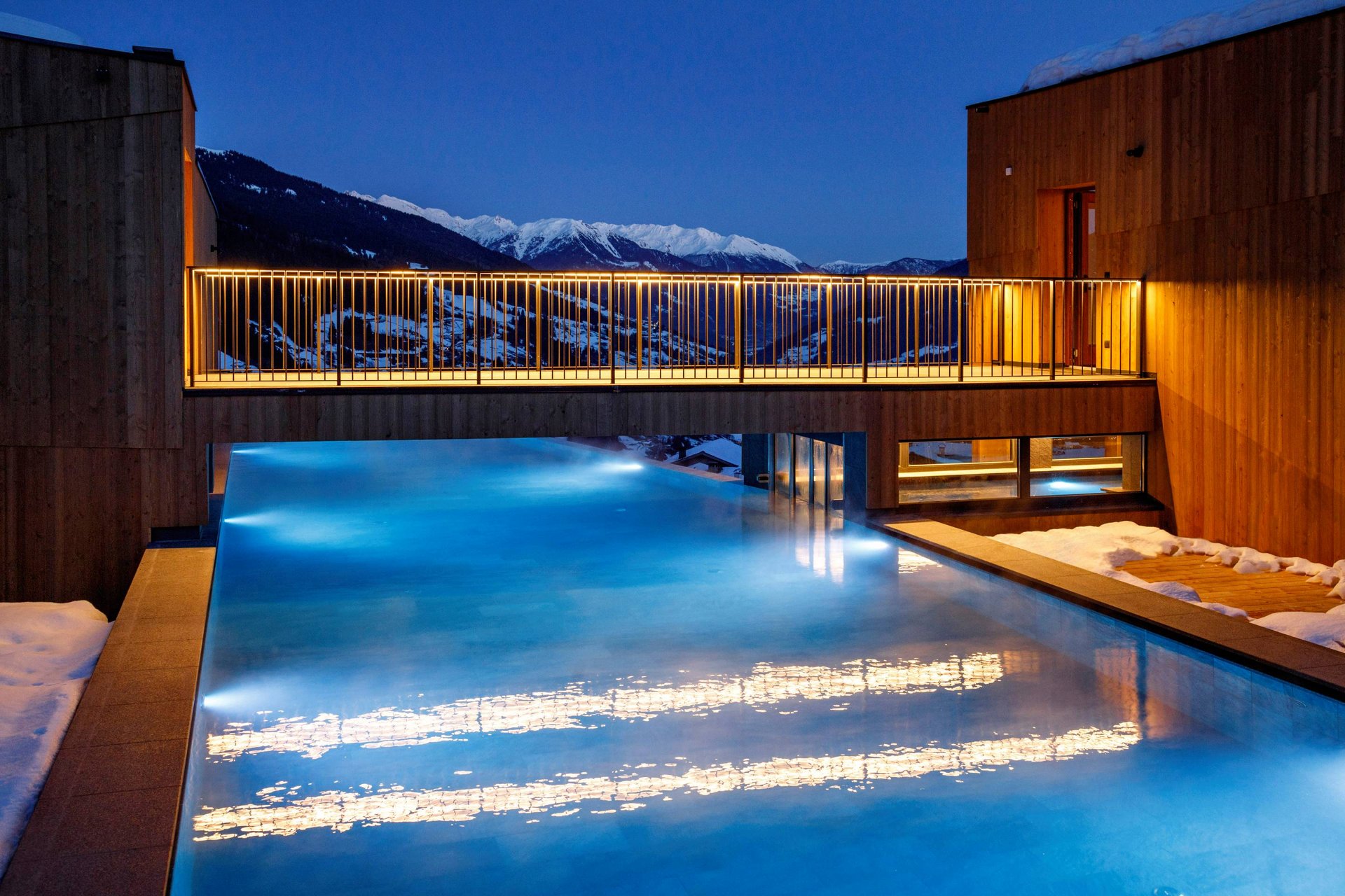 Urlaub anfragen Beleuchteter Außenpool bei Nacht mit Bergblick und Schnee