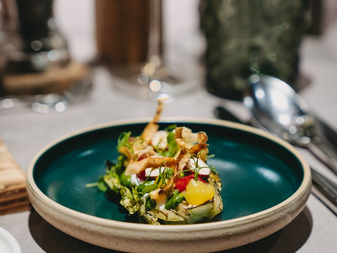 Der Erlebnisort Gassenhof Kunstvoll angerichtetes Feinschmeckergericht auf grünem Teller in elegantem Restaurant