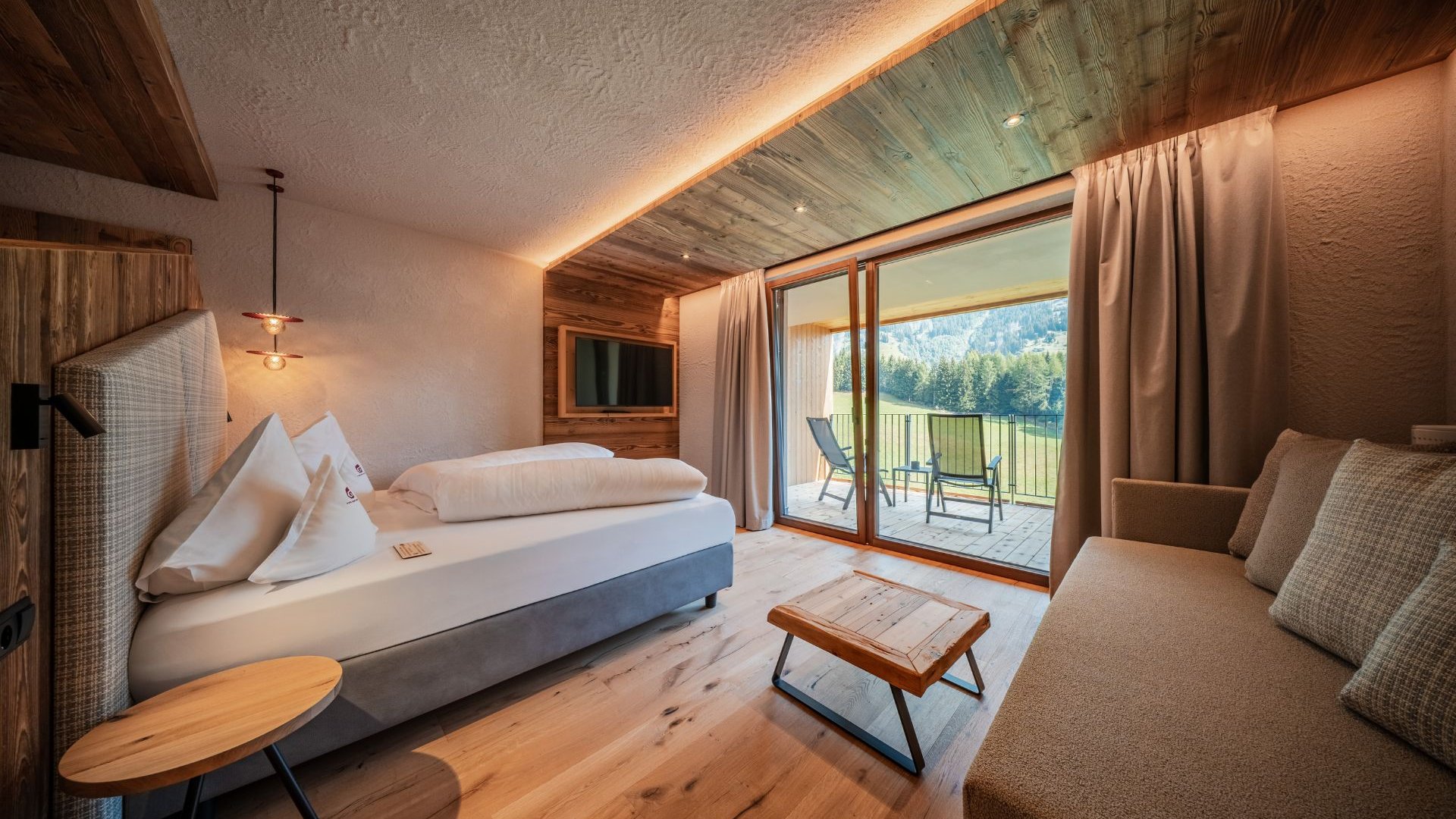 Neu bei uns im Gassenhof Modernes Zimmer mit Bett, Sofa und Balkon mit Bergblick