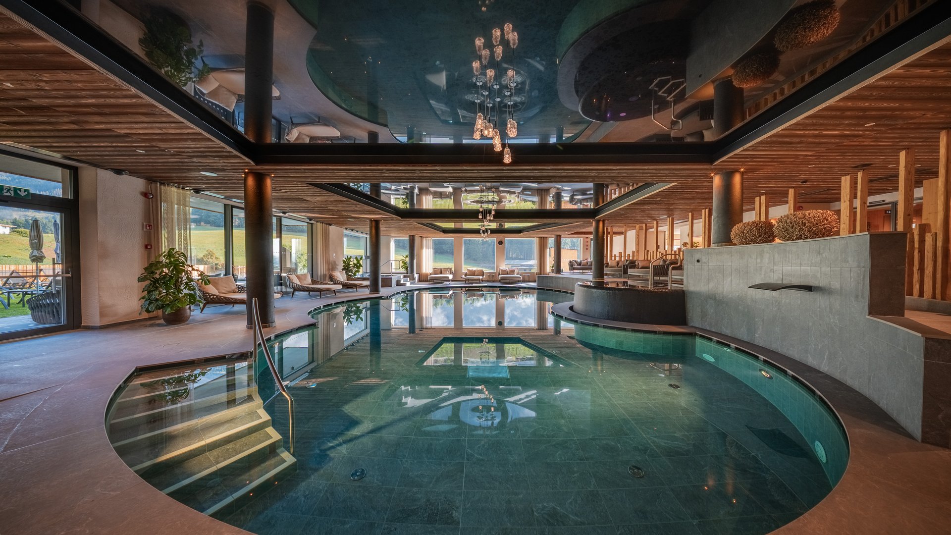 Wellness im Erlebnishotel Gassenhof Elegantes Hallenbad mit rundem Pool, Liegen und Holzdecke