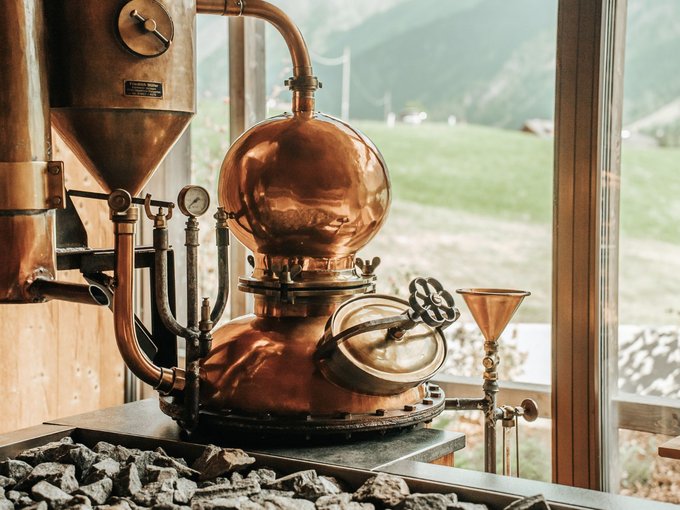 L’area wellness riservata agli adulti Impianto di distillazione in rame davanti a una finestra con paesaggio montano