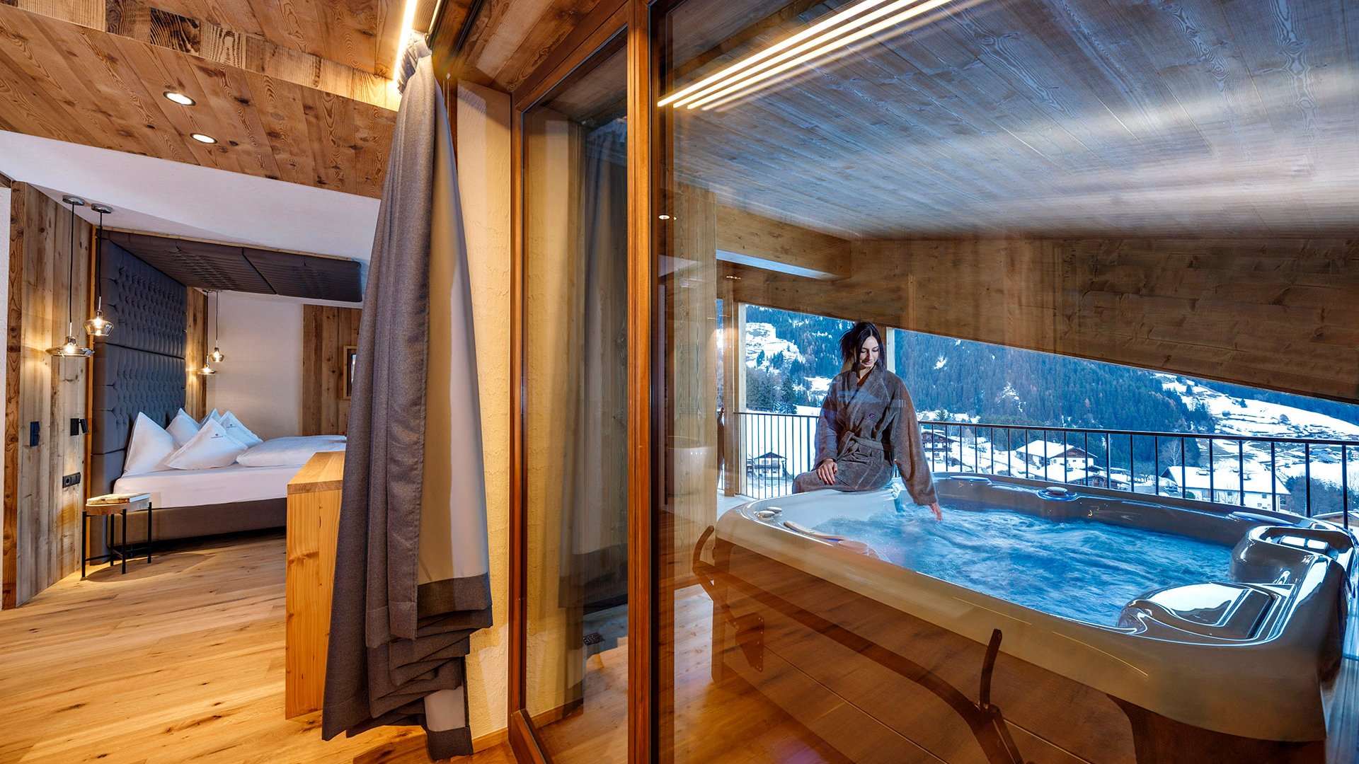 The best spot in the Ridnauntal valley Woman in bathrobe at hot tub on wooden balcony with mountain view