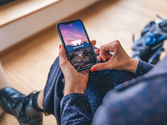 Wanderhotel Persona tiene smartphone con l'app Wanderhotels aperta