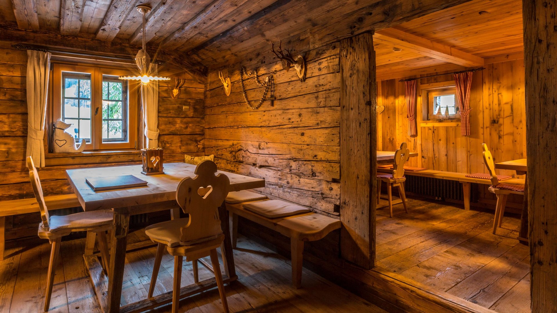 Traditional cuisine at Chalet Gratznhäusl Cozy room in a rustic wooden cabin with wooden tables and chairs