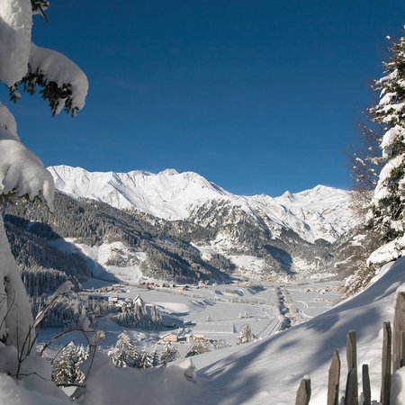 La Val Ridanna Paesaggio montano innevato con alberi e villaggio sotto cielo blu