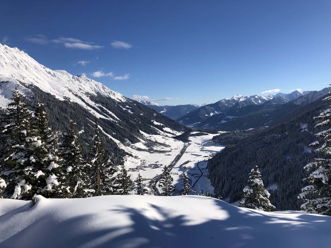 Our weekly programme Snow-covered valley and mountains under clear blue sky