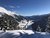 Verschneites Tal und Berge unter klarem blauen Himmel