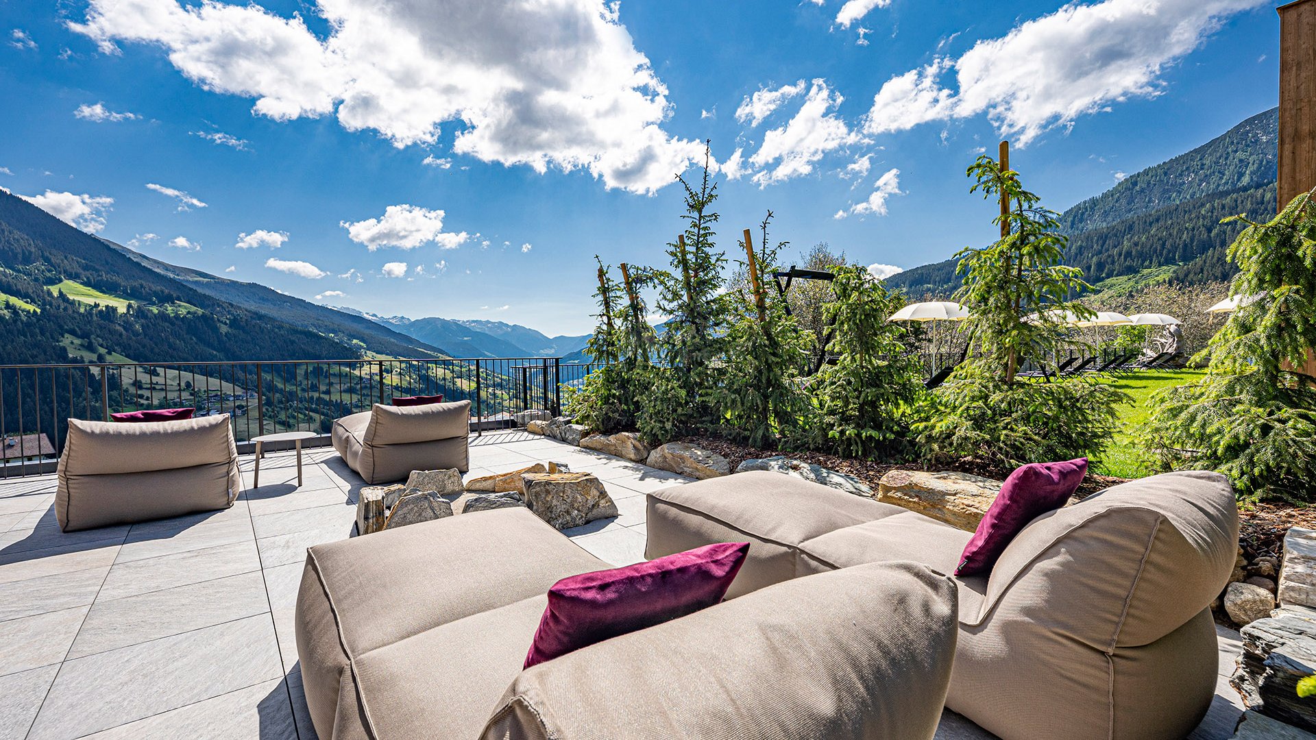 Hotel a Racines con centro benessere Mobili da esterno moderni con vista sulle montagne sotto cielo azzurro