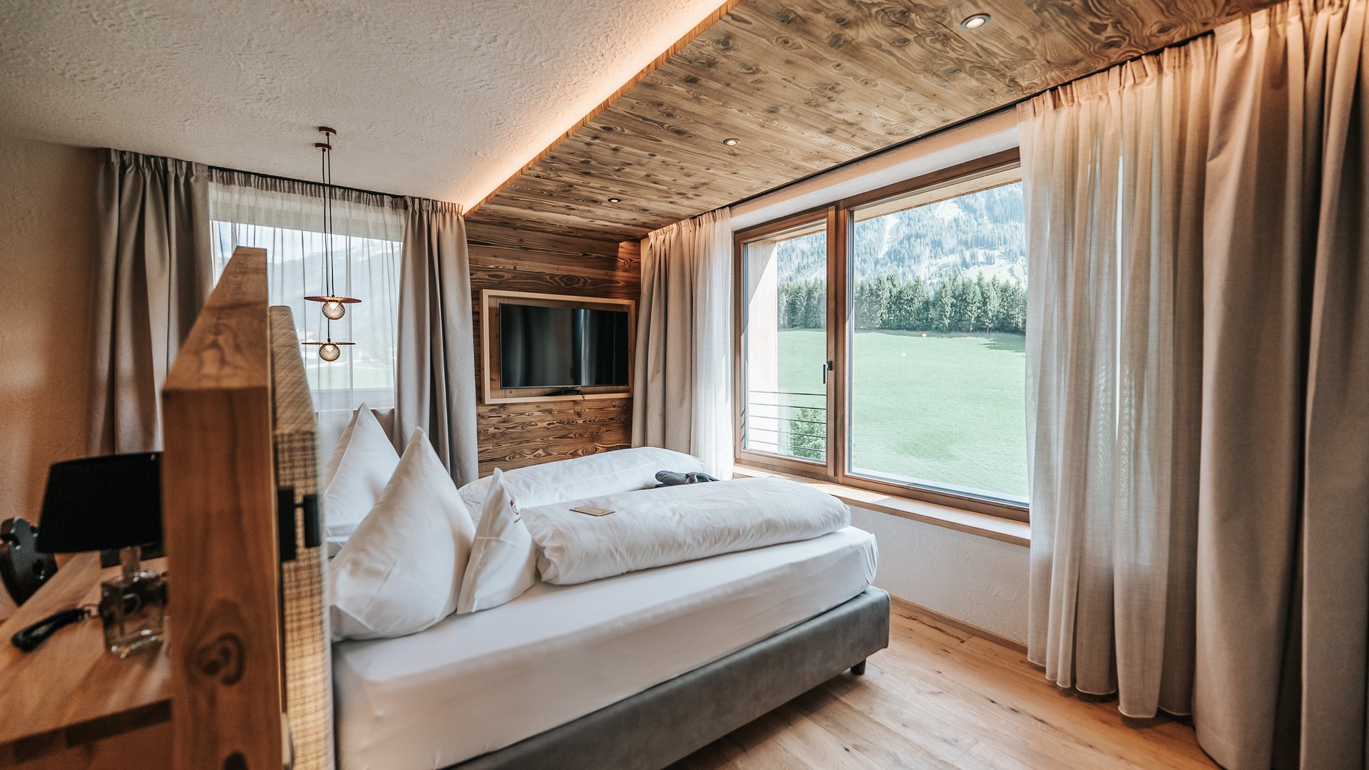 New at Gassenhof Cozy hotel room with wooden accents and large window overlooking mountain view