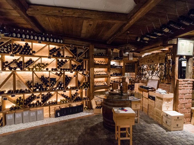 Vini Cantina con scaffali in legno e molte bottiglie di vino