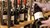 Hände halten eine Weinflasche in einem Weinregal