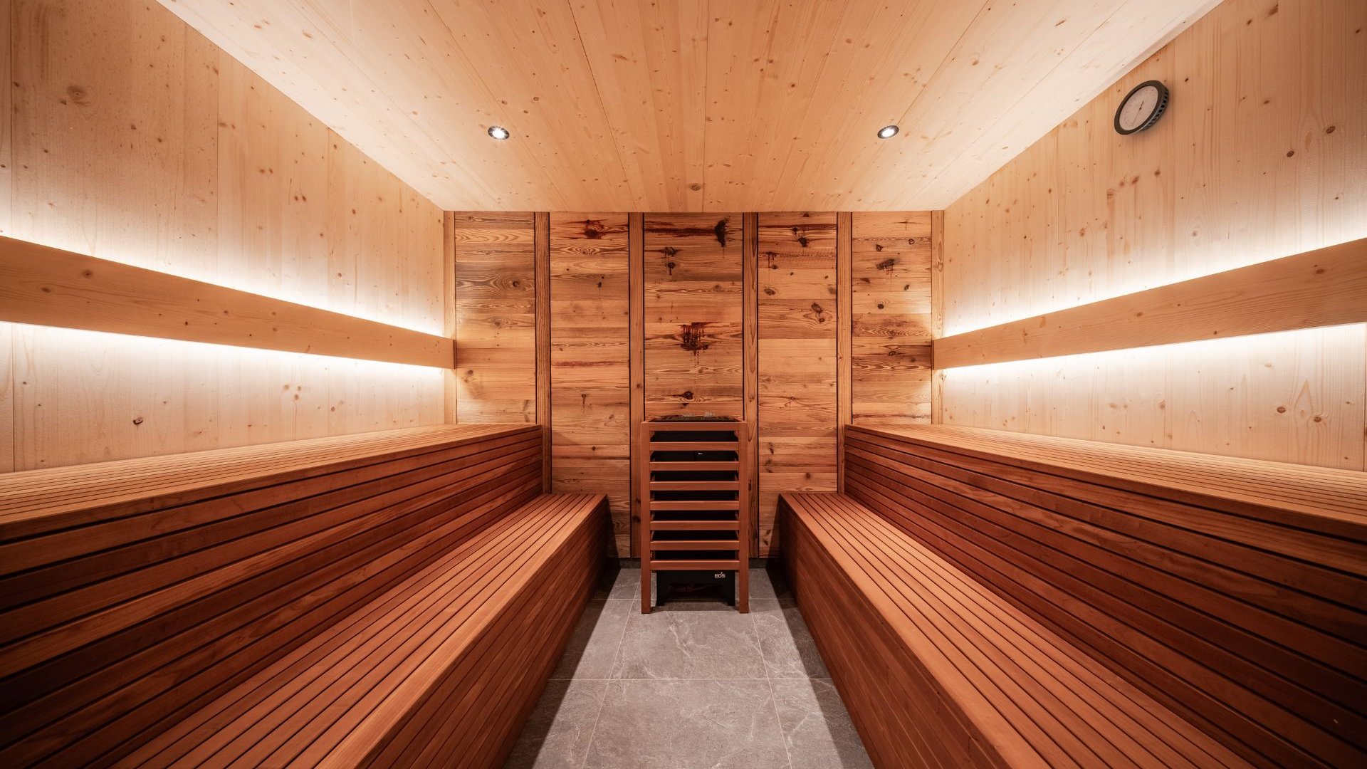 Gassenbadl: l’area wellness per famiglie Sauna in legno con due panche, schienali e stufa per sauna