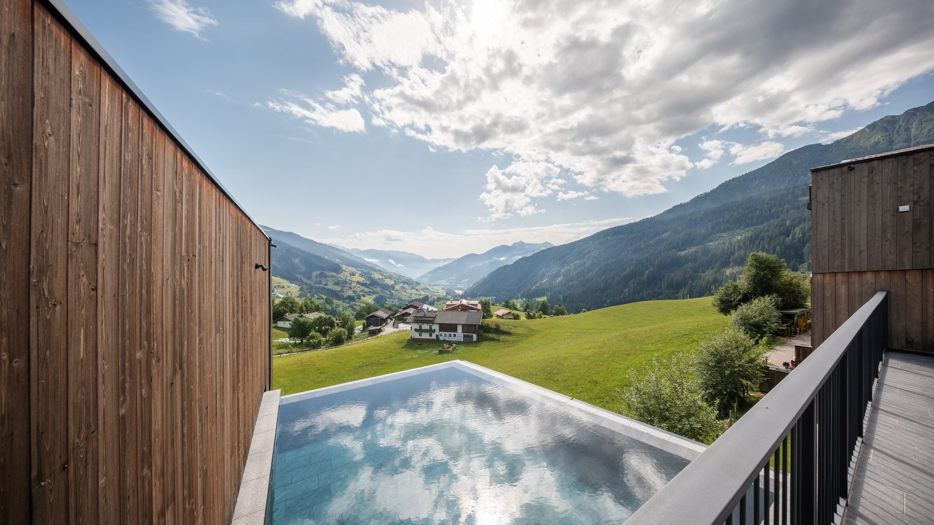 L’area wellness riservata agli adulti Piscina su una terrazza con vista su una valle alpina verde e montagne