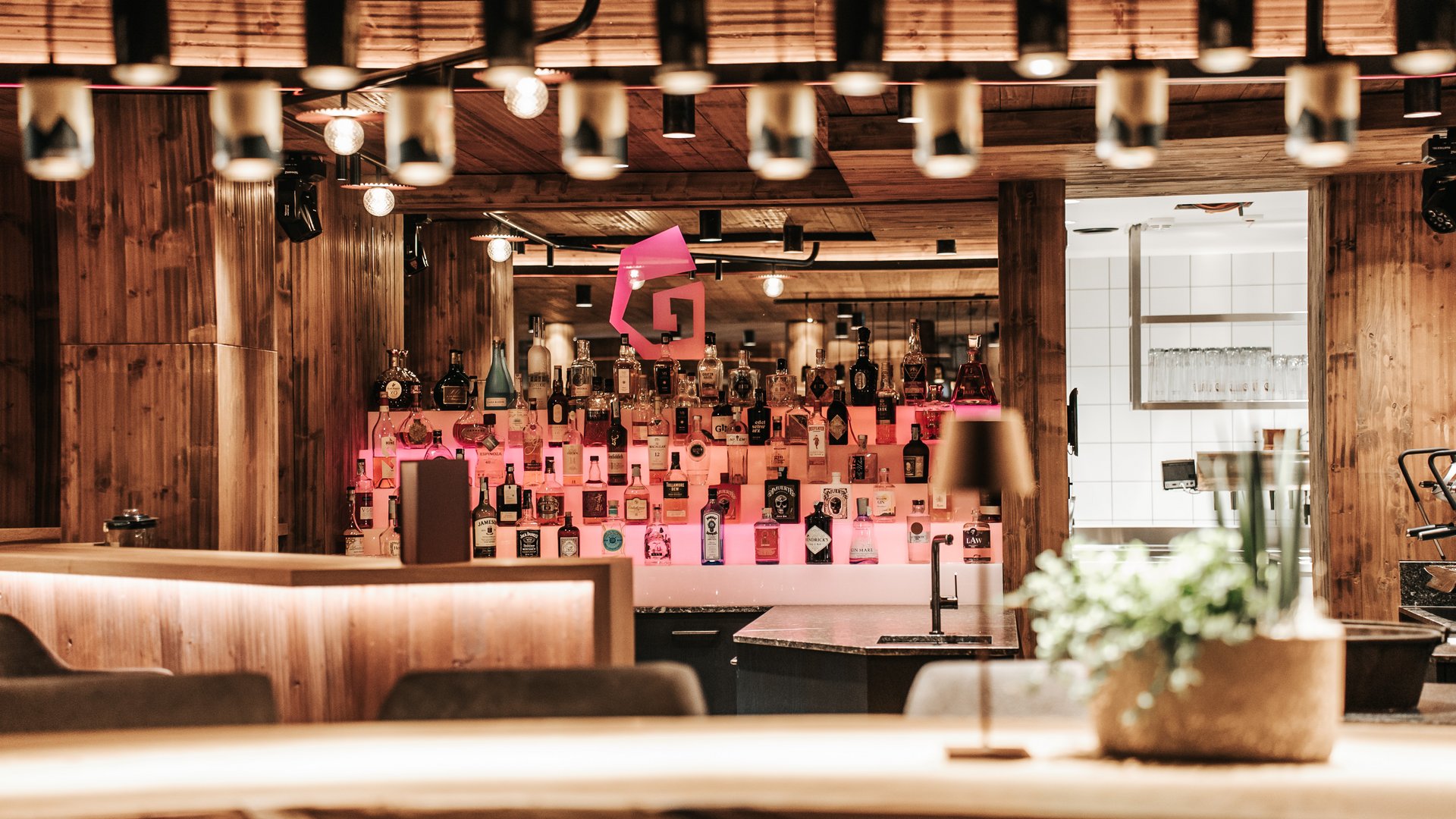 New at Gassenhof Modern bar with wooden paneling and illuminated liquor bottles