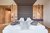 Moderne Hotelzimmer mit Holzwänden, großem Polsterbett und grauen Bademänteln