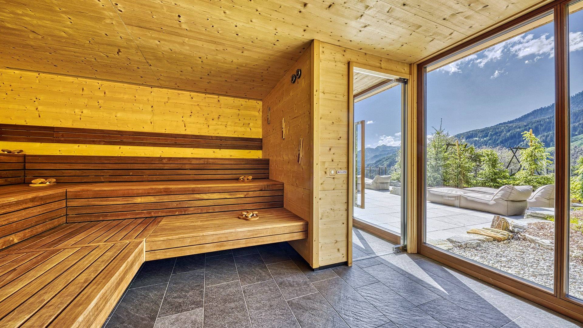 Modern wooden sauna interior with panoramic window and mountain view
