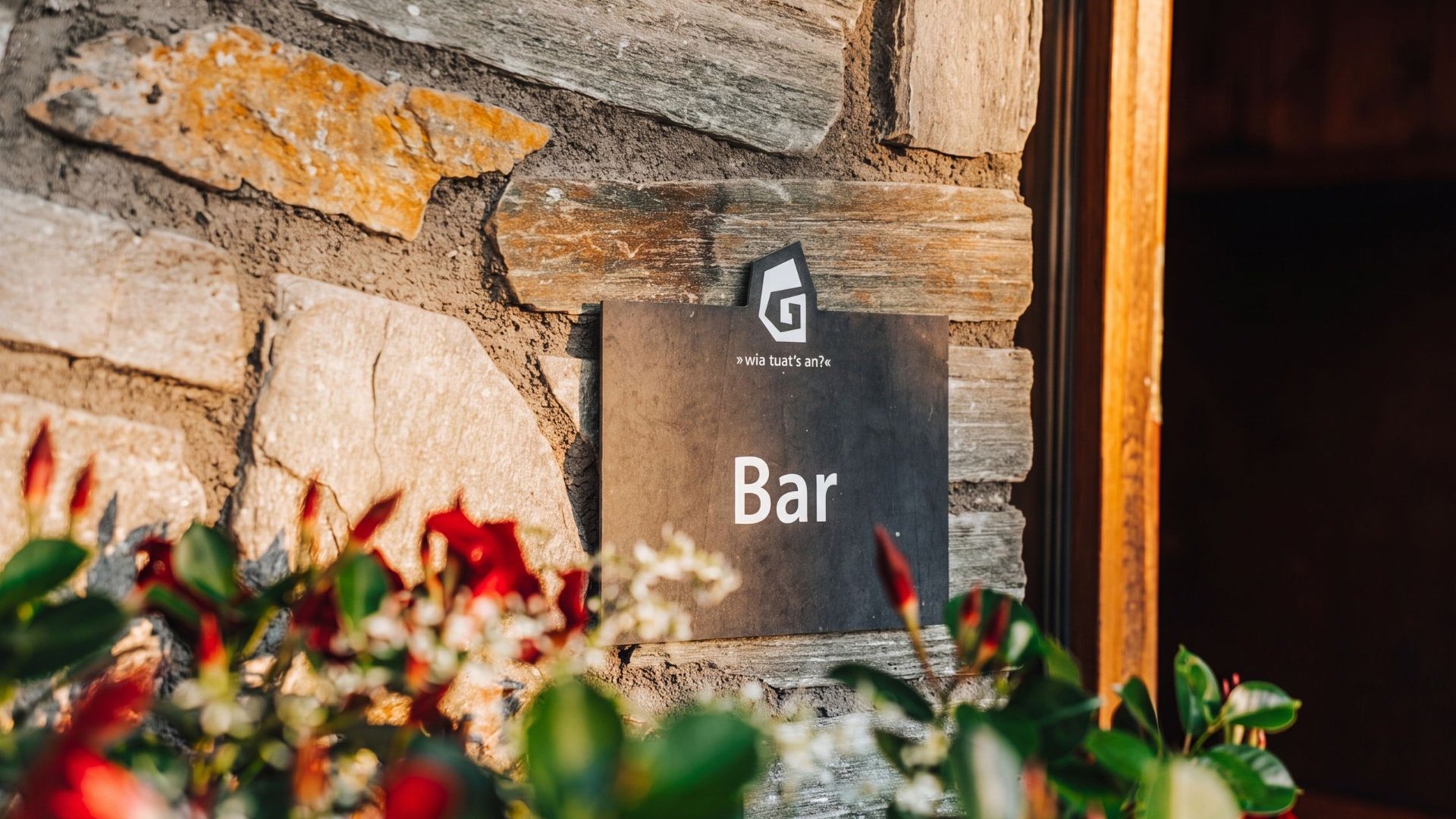 Servizi inclusi Cartello con la scritta Bar su una parete in pietra accanto a un ingresso