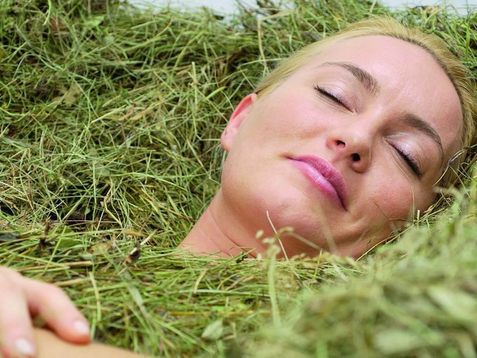 Vitalpina hotel in Alto Adige Donna rilassata con occhi chiusi tra il fieno