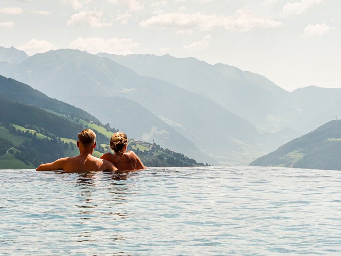 Das Wellnessbereich für Erwachsene Paar entspannt im Infinity-Pool mit Blick auf Berglandschaft