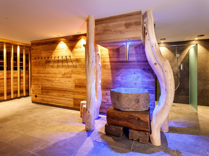 Regno della Sauna Area benessere moderna con rivestimenti in legno e fontana di pietra con luce blu
