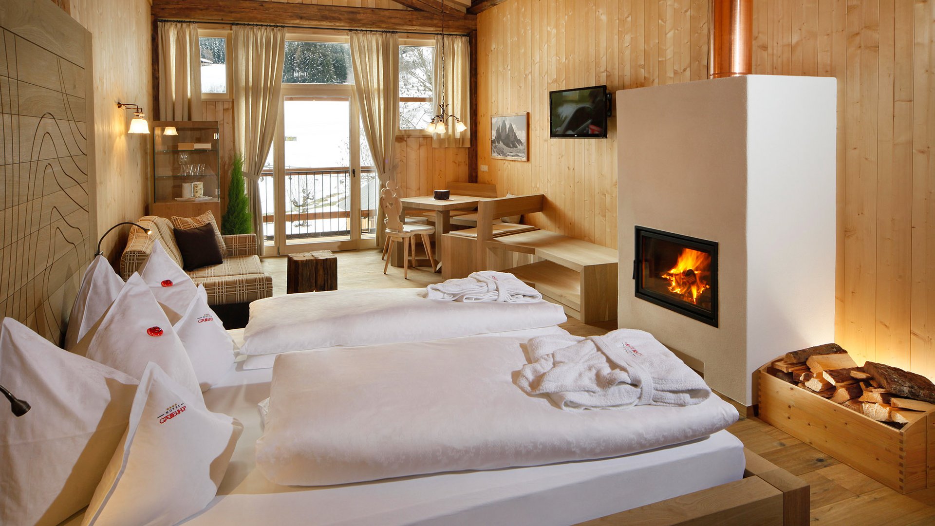 Zimmer und Suiten Gemütliches Hotelzimmer mit Kamin, Bett und Holzwänden