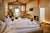 Gemütliches Hotelzimmer mit Kamin, Bett und Holzwänden