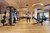 Zwei Menschen trainieren mit Gewichten in modernem Fitnessraum mit Holzdecke