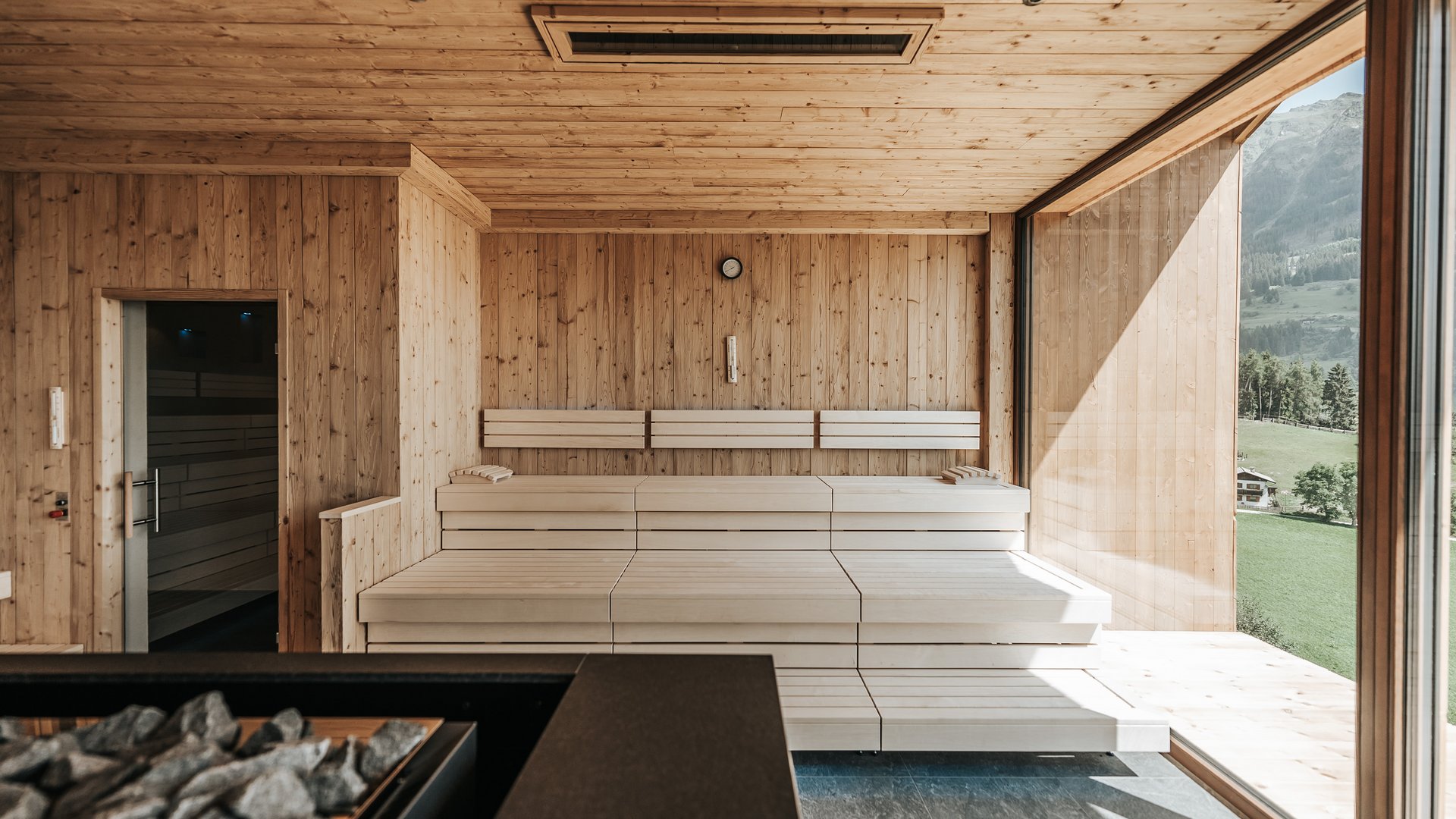 Our sauna realm Modern sauna with wooden walls and large glass window overlooking mountains