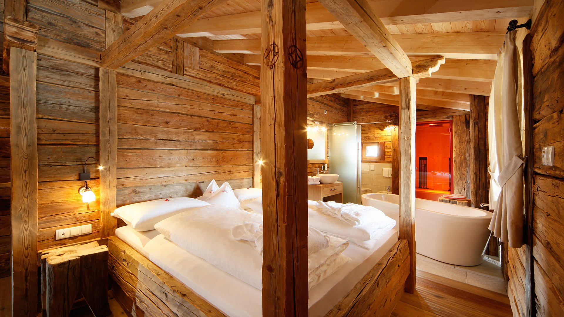 The historical Chalet Gratznhäusl Rustic bedroom with wooden frame bed and freestanding bathtub