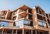 Galleria immagini Edificio moderno in legno con balconi e base in pietra sotto il cielo azzurro