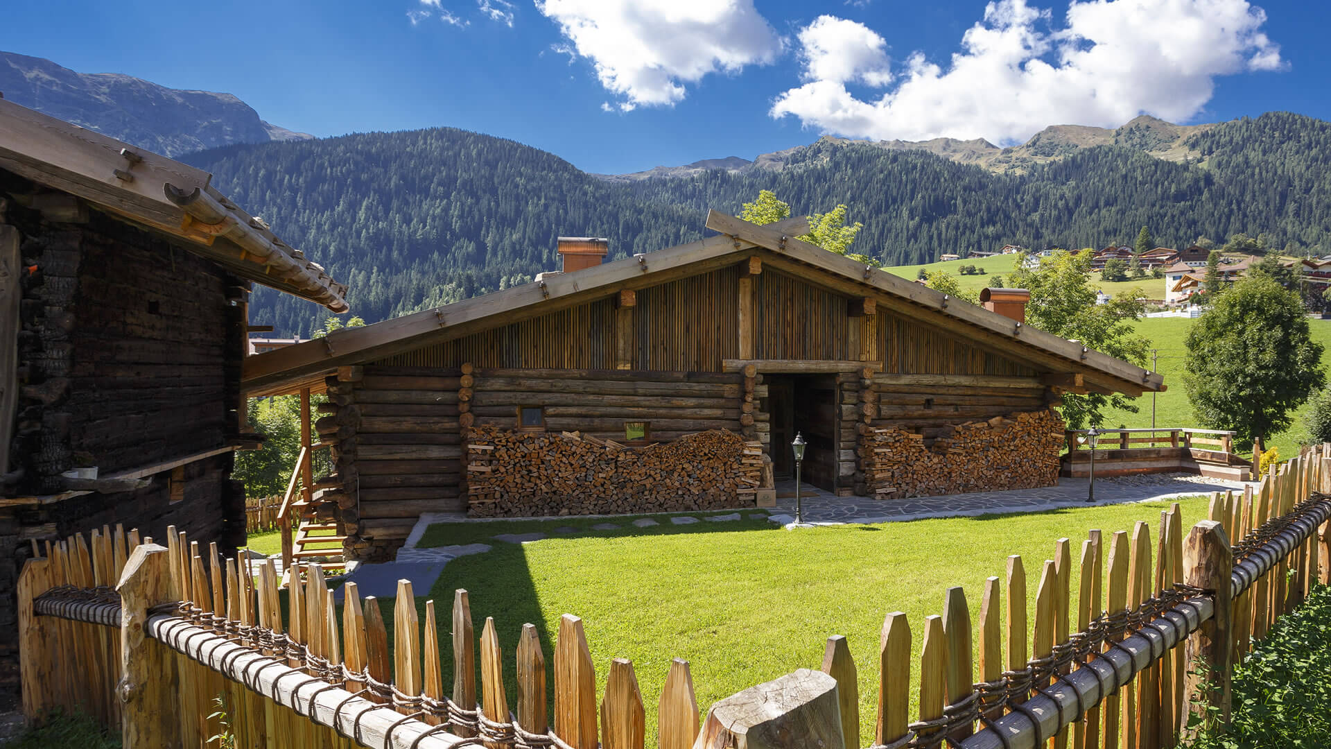 The historical Chalet Gratznhäusl Wooden house with fence and mountain landscape in the background under blue sky