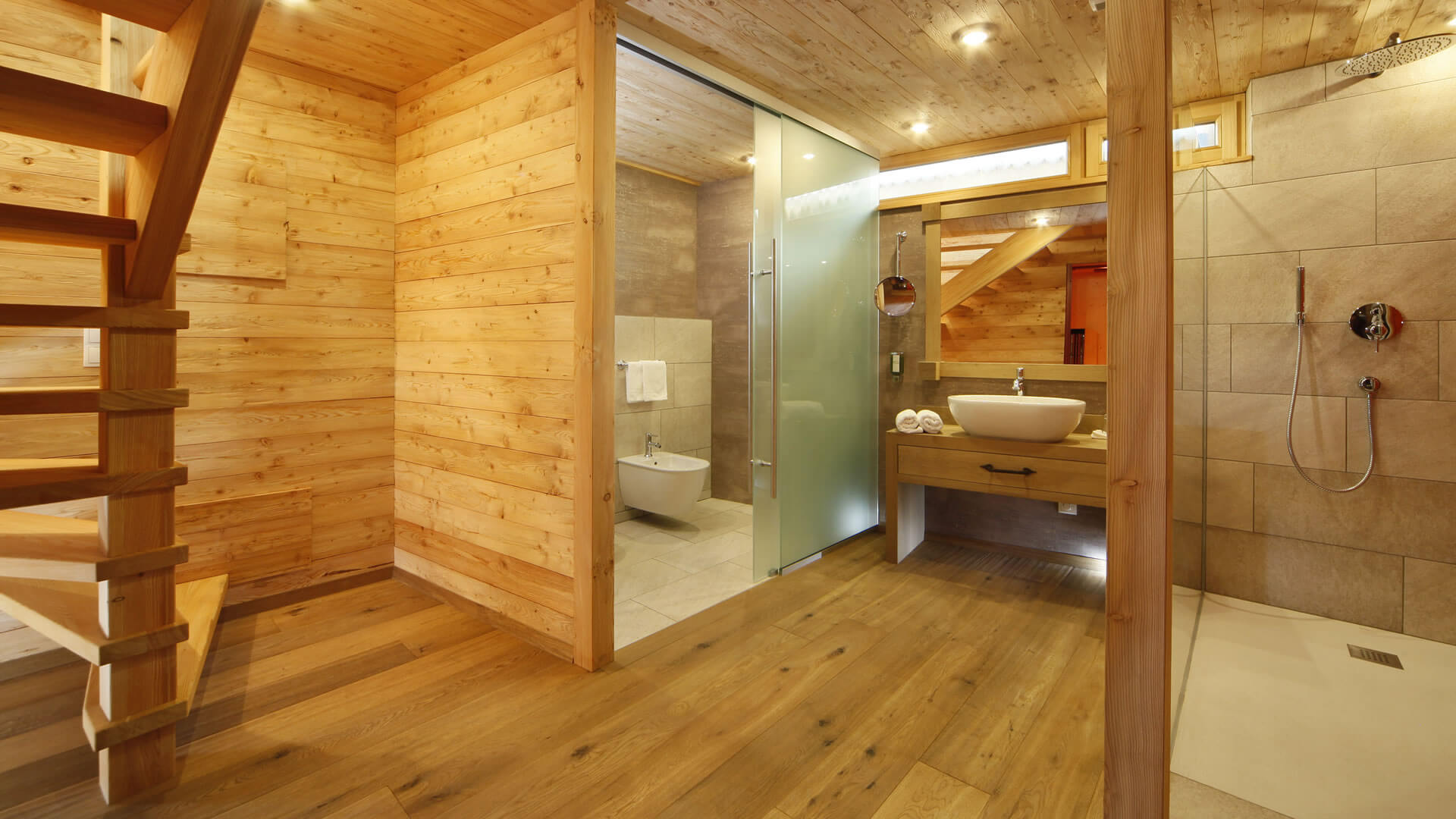 The historical Chalet Gratznhäusl Modern bathroom with wooden paneling, shower, sink, and staircase